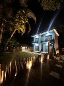 ein Gebäude mit einer Palme in der Nacht davor in der Unterkunft Suítes Flor de Maio in Porto Seguro