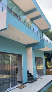 ein blaues Haus mit einer Treppe in der Unterkunft Suítes Flor de Maio in Porto Seguro