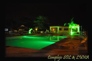 uma piscina à noite com luzes verdes em Complejo Sol y Luna em Gualeguaychú