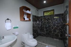 a bathroom with a shower and a toilet and a sink at Las Marias Monteverde - Mountain View Cottages & Gardens in Monteverde Costa Rica +46 photos