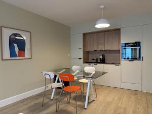 a kitchen with a table and chairs in a room at Le Pantone in Neufchâteau