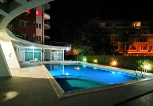 a swimming pool at night next to a building at Luisa Lux Apartment - Sat Vacanta in Mamaia