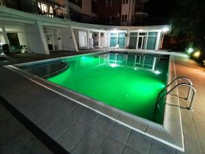 a pool with green illumination in a house at night at Luisa Lux Apartment - Sat Vacanta in Mamaia