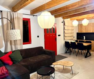a living room with a couch and a red door at Casa de Rowosz - domki i apartamenty nad morzem in Rowy