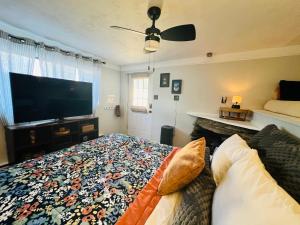 a bedroom with a bed and a flat screen tv at Mountain Lake Retreat - hot tub, lake, fire pit, wineries, restaurant in Harpers Ferry