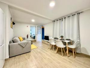 a living room with a couch and a table and chairs at Casa do Perestrelo - Guest House in Machico
