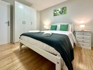 a bedroom with a large bed with green pillows at Casa do Perestrelo - Guest House in Machico