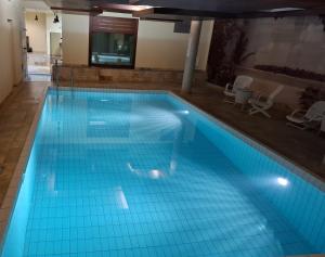 莱森Le Nid d'aigle apt Leysin centre avec forfait piscine sauna jacuzzi en option的建筑物内铺有蓝色瓷砖的大型游泳池