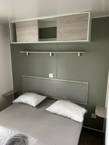 Un dormitorio con una cama con dos almohadas blancas. en Mobil - home ombragé Lege Cap ferret, en Lège-Cap-Ferret 29 fotos más