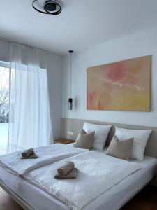 a bedroom with a large white bed with two towels on it at Stylisches Design-Apartment in Rottenmann