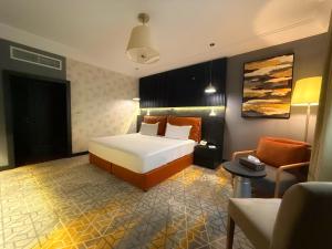 ein Hotelzimmer mit einem Bett und einer Couch in der Unterkunft Crown Town Hotel in Dschidda