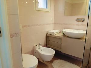 a white bathroom with a sink and a toilet at Casa Vacanza Martino in Matera +20 photos