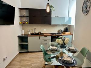 a kitchen with a glass table and green chairs at Dimora Sangallo in Caprarola