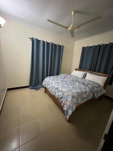 a bedroom with a bed with blue curtains at Jefes Haven in Dar es Salaam