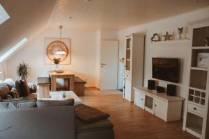 a living room with a couch and a tv at Studio an der Ilmenau in Lüneburg