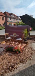 a patio with a table and chairs and an umbrella at Studio an der Ilmenau in Lüneburg