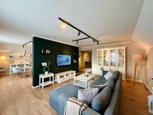a living room with a couch and a tv at VILLARE8 OG APARTMENT - Moderne Wohnung im Landkreis Gifhorn in Adenbüttel