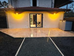 a house with a large patio with a door at Chez Tom et Yas in Le Barp