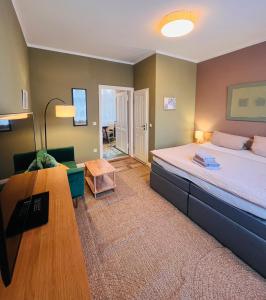 a bedroom with a bed and a couch and a table at Pension im historischen Bahnhof von Fehrbellin! in Fehrbellin +30 photos
