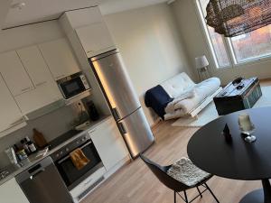a small kitchen with a table and a dining room at Bohemian Luxury with private Sauna, own carparking, 3 km from airport in Vantaa