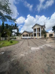 a house with a driveway in front of it at Jefes Haven in Dar es Salaam +3 photos