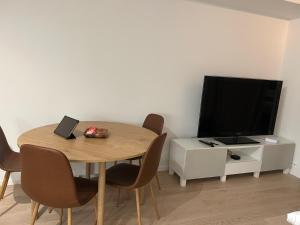 a dining room with a table and a television at City Center ocean view Vervet apartment in Tromsø