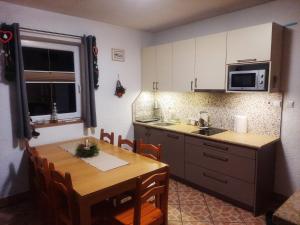 a kitchen with a wooden table and a kitchen with a table and chairs at Domki Pod Jesionami in Stronie Śląskie