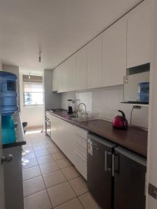 a kitchen with white cabinets and a counter top at Parque Mirador II - 3 Dormitorios - Excelente vista in Viña del Mar