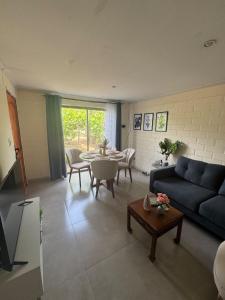 a living room with a blue couch and a table at Casa Privada Descanso Naturaleza in Maule