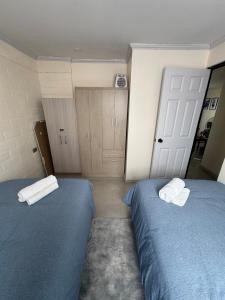a bedroom with two beds and a door with towels at Casa Privada Descanso Naturaleza in Maule