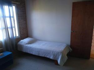 Un dormitorio pequeño con una cama y una ventana. en Los Sauces, en Playas Doradas