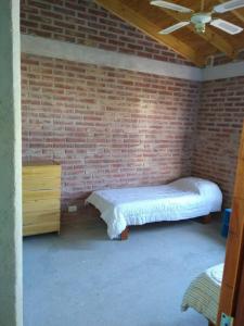 Una pared de ladrillos con una cama en una habitación. en Los Sauces, en Playas Doradas