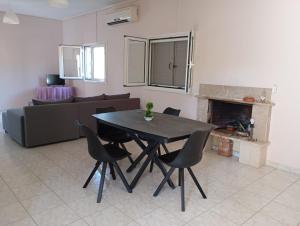 a dining room table and chairs in a living room at Ilektras Haus in Mavrommátion +5 photos