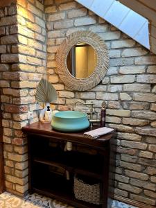 a bathroom with a sink and a mirror on a stone wall at Kaimukas - lake house for 15 persons 5 bedrooms in Dvarčėnai +120 photos