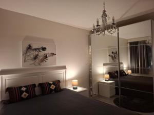 a bedroom with a bed and a chandelier at City Apartment Snellmaninkatu 22 A, yksityinen pistokkeellinen paikoitus sisältyy hintaan in Kuopio