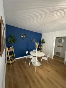 a table and chairs in a room with a blue wall at Au calme in Saint-Brieuc