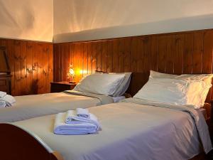 two beds in a hotel room with towels on them at Good Stay Borno in Borno
