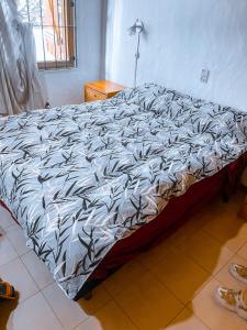 a bed with a black and white comforter in a bedroom at Casa Sanbernardo costa azul muy grande in San Bernardo