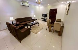 a living room with a couch and a table at AL Mokhmalia Serviced Apartments in Medina