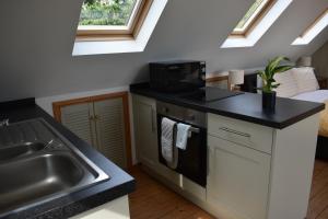 a kitchen with a sink and a microwave at Frogwell in Strete
