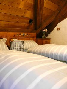 two beds in a room with wooden ceilings at Der Grandlhof - Ferien am Hof in Krummennaab