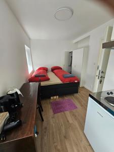 a small bedroom with a bed with red pillows at Private Apartment Drammen in Drammen