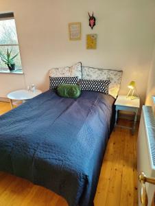 a bedroom with a bed with a blue comforter at Guest house on farm in small village in Næstved