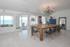 a dining room with a wooden table and chairs at Bella Vita in Yzerfontein