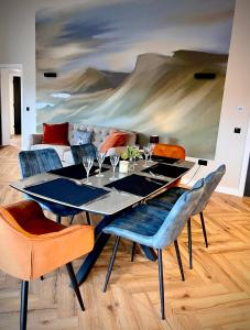 a dining room with a table with chairs and a painting at Luxury 3 Bedroom House - Stag Moor House in Portree
