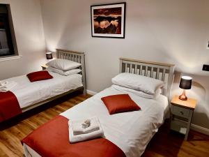 a bedroom with two beds and a picture on the wall at Luxury 3 Bedroom House - Stag Moor House in Portree