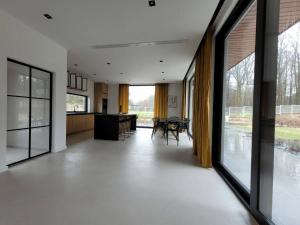 an open living room with large windows and a dining area at Ostatni dom po lewej in Białe Błoto
