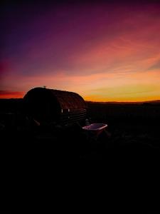 an old barrel sitting in a field at sunset at The Bonnie Wee Bothy in East Linton