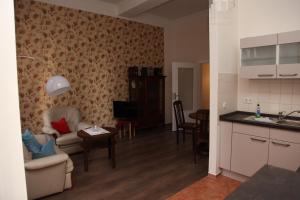 a kitchen and a living room with a table and chairs at Ferienwohnung Höllenblick in Quedlinburg