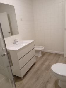 a white bathroom with a sink and a toilet at Paseo de Noia in Noya